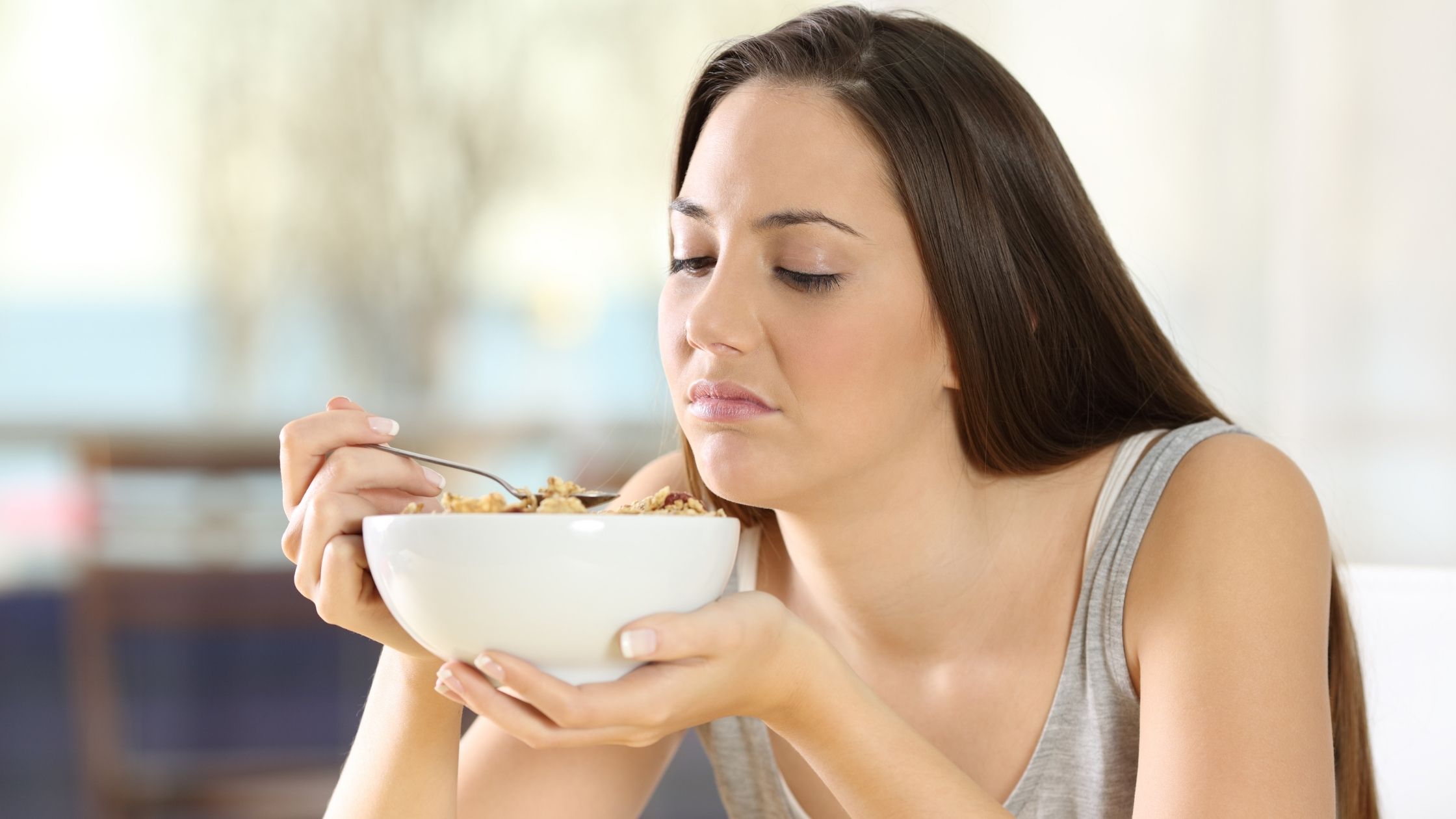 A women eating a bowel or cereal trying to increase fiber